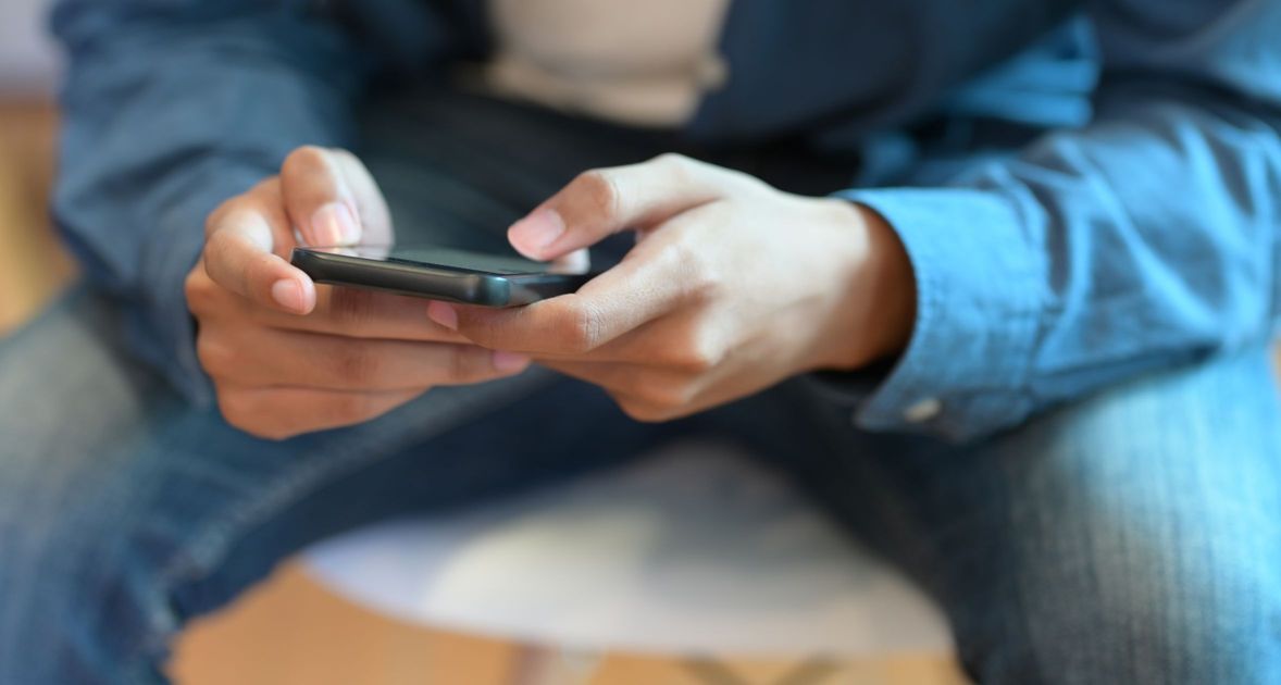 スマートフォンでビジネス活動を行う若いビジネスマンの画像